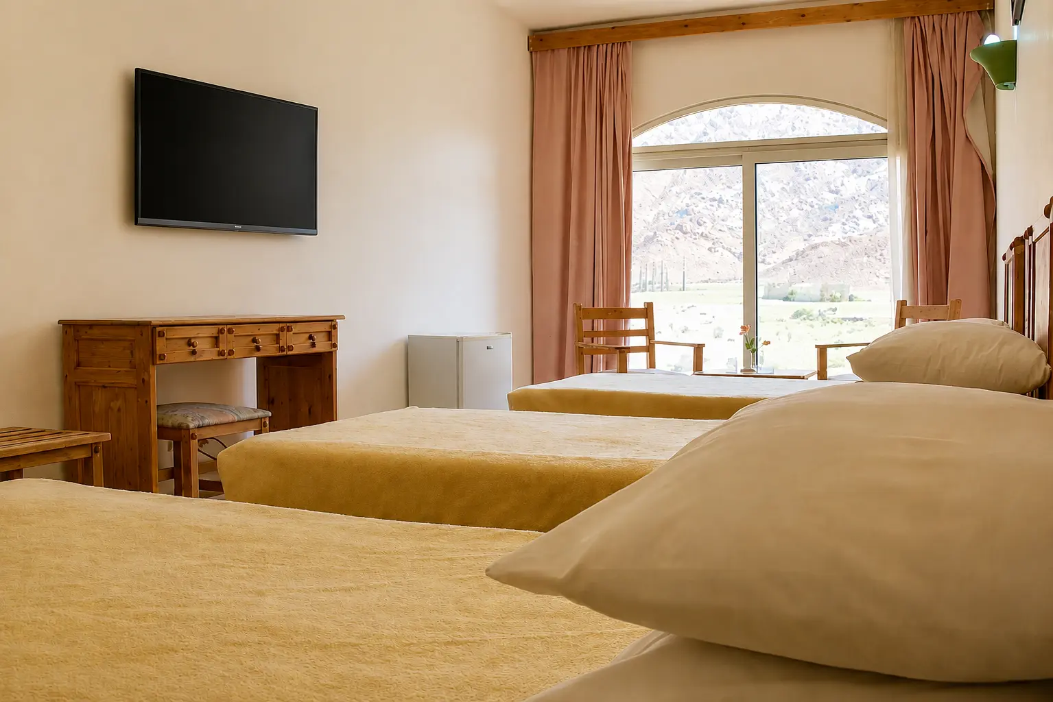 Triple room with a mountain view through the arched window
