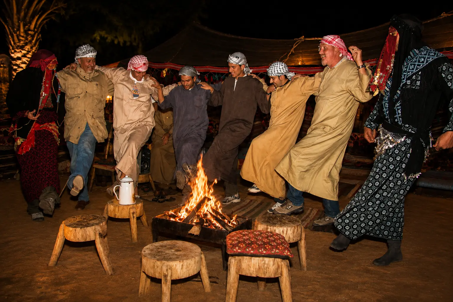 Guests dancing with Bedouin hosts around the fire at night