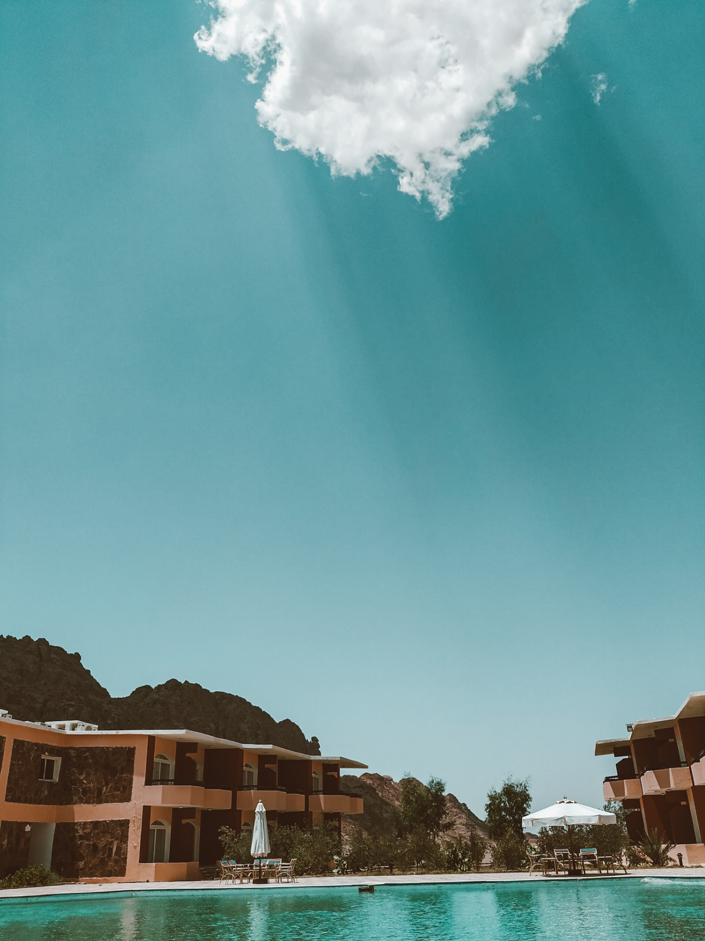 Village buildings and pool under a wide blue Saint Catherine sky