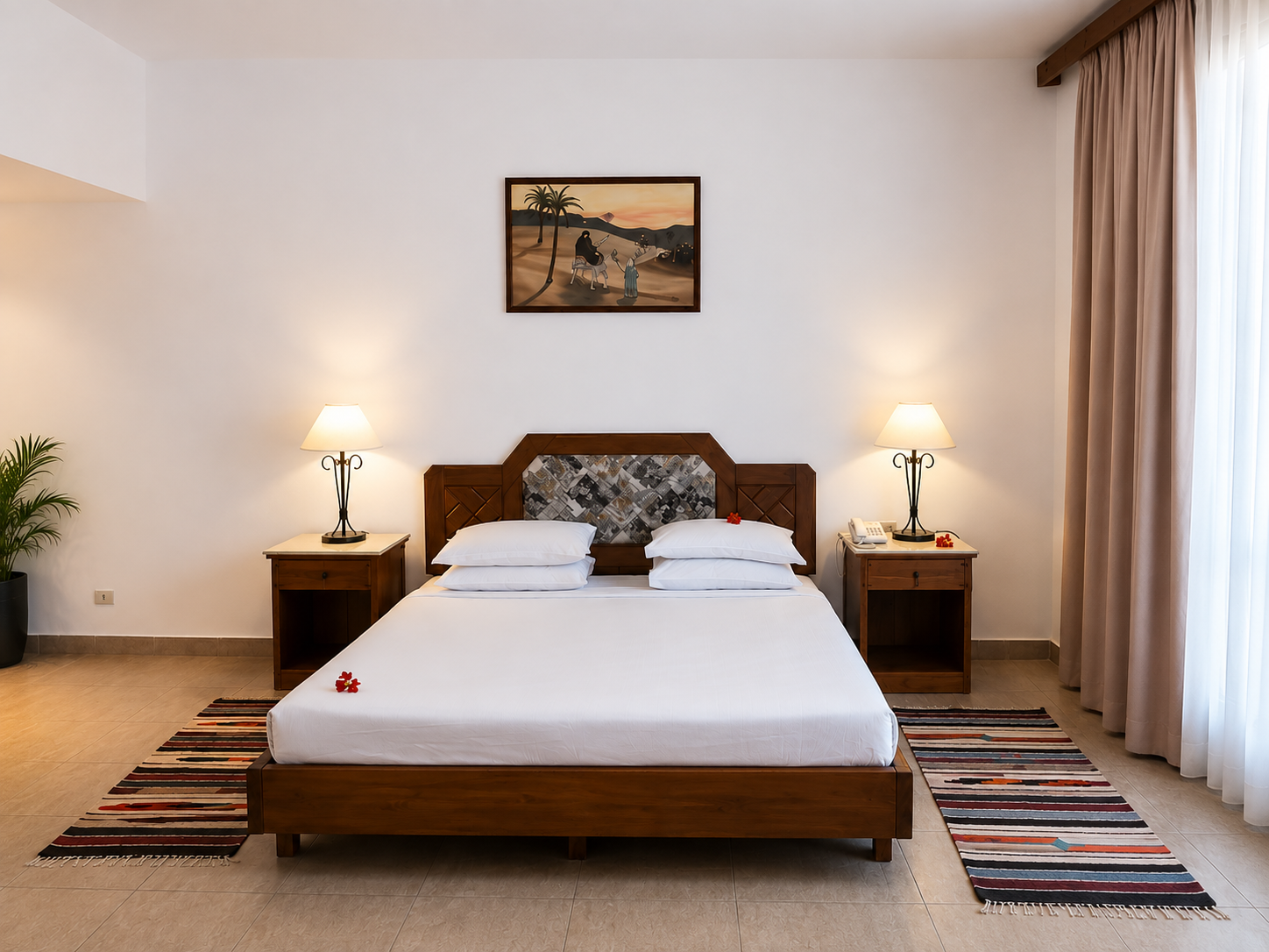 Bright hotel bedroom with a double bed and colorful rugs