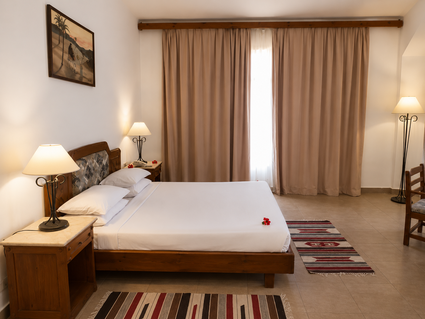 Side view of a hotel bedroom with a large window and wooden furniture