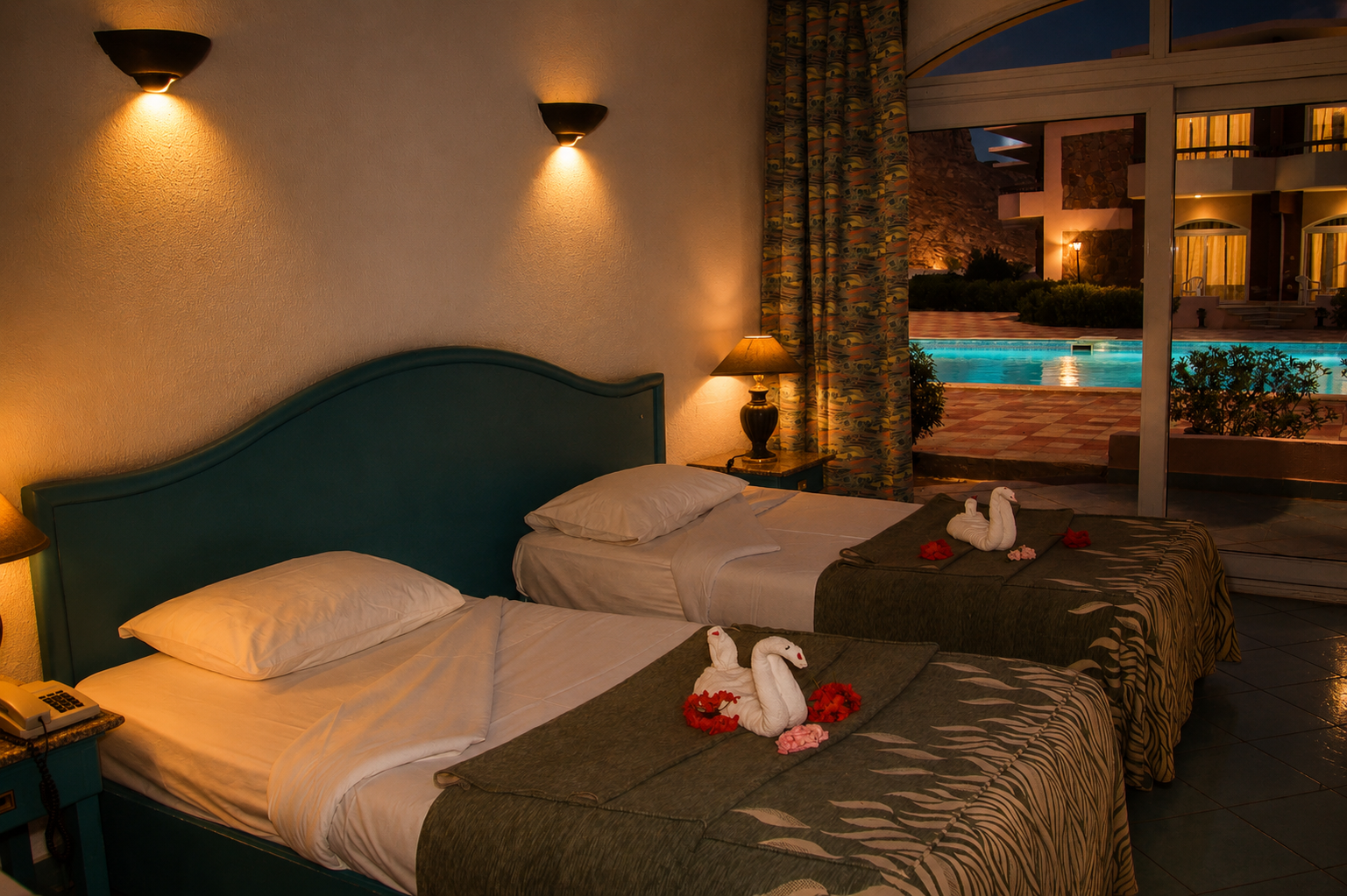 Twin bedroom at night with swan-shaped towel art on the beds