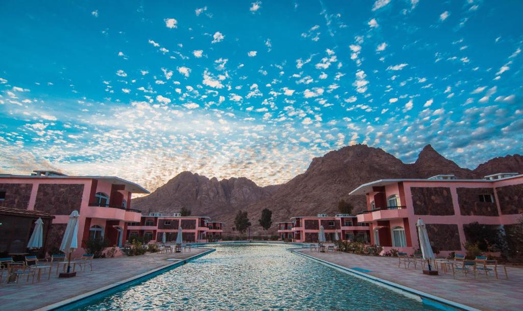 Wide view of the village pool and buildings under a cloudy sunset sky